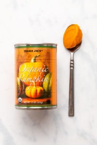 Can of Trader Joe's pumpkin puree next to spoon with puree on it