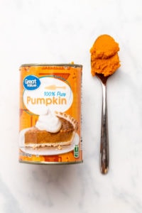Can of Walmart's Great Value pumpkin puree next to spoon with puree on it