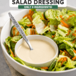 Small bowl of hummus salad dressing in larger bowl of salad mix