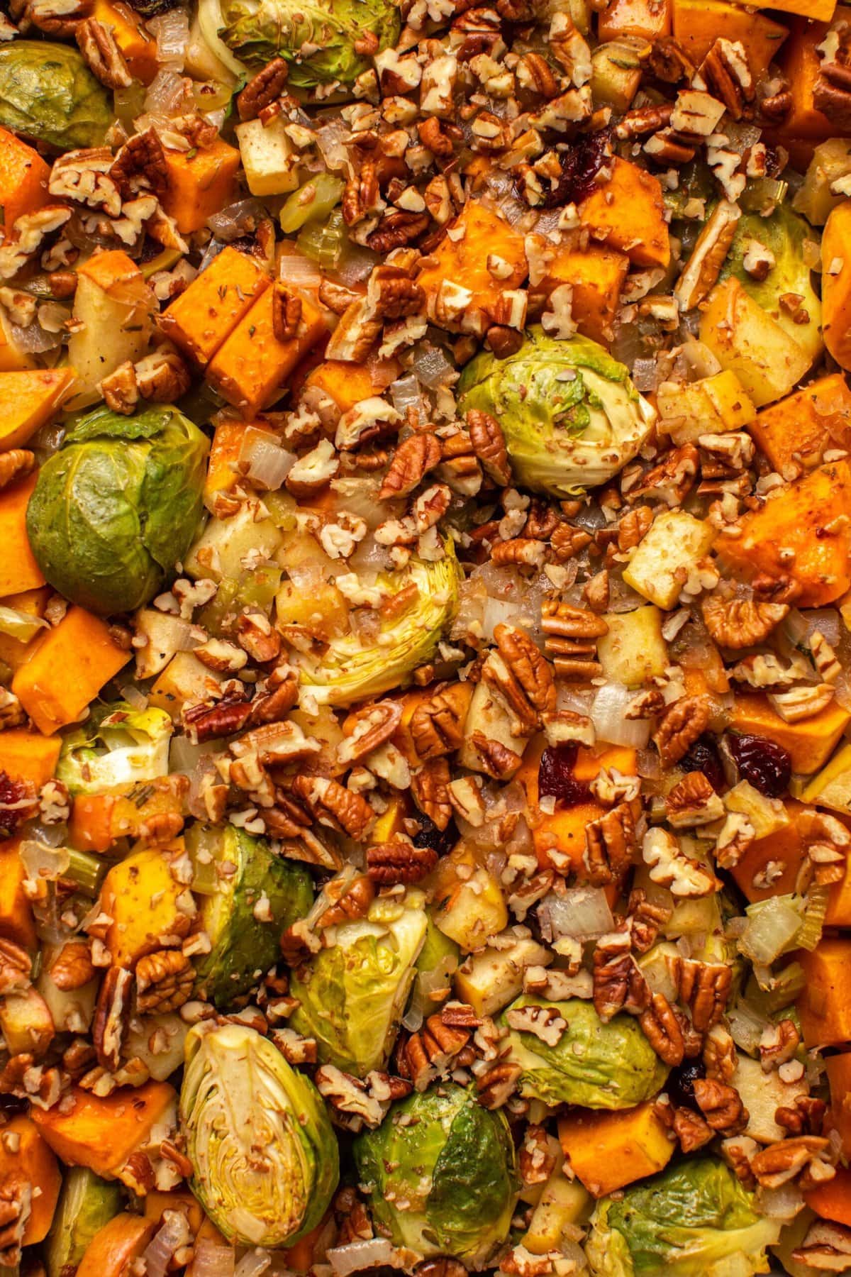 Close-up photo of cooked brussels sprouts and butternut squash topped with pecans 