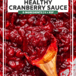 Cooked cranberry sauce in sauté pan with a wooden spoon