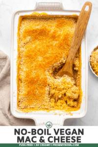 Baked Vegan Mac & Cheese topped with golden breadcrumbs in white casserole dish with wooden spoon