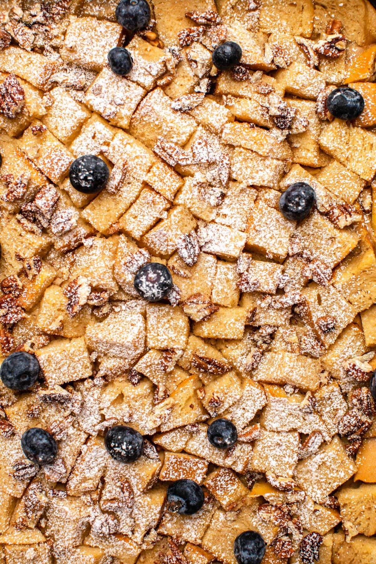 Close-up of baked french toast topped with blueberries and powdered sugar