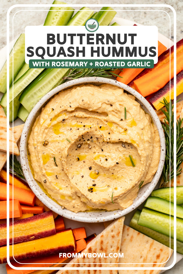 Bowl of butternut squash hummus on veggie platter topped with olive oil and black pepper