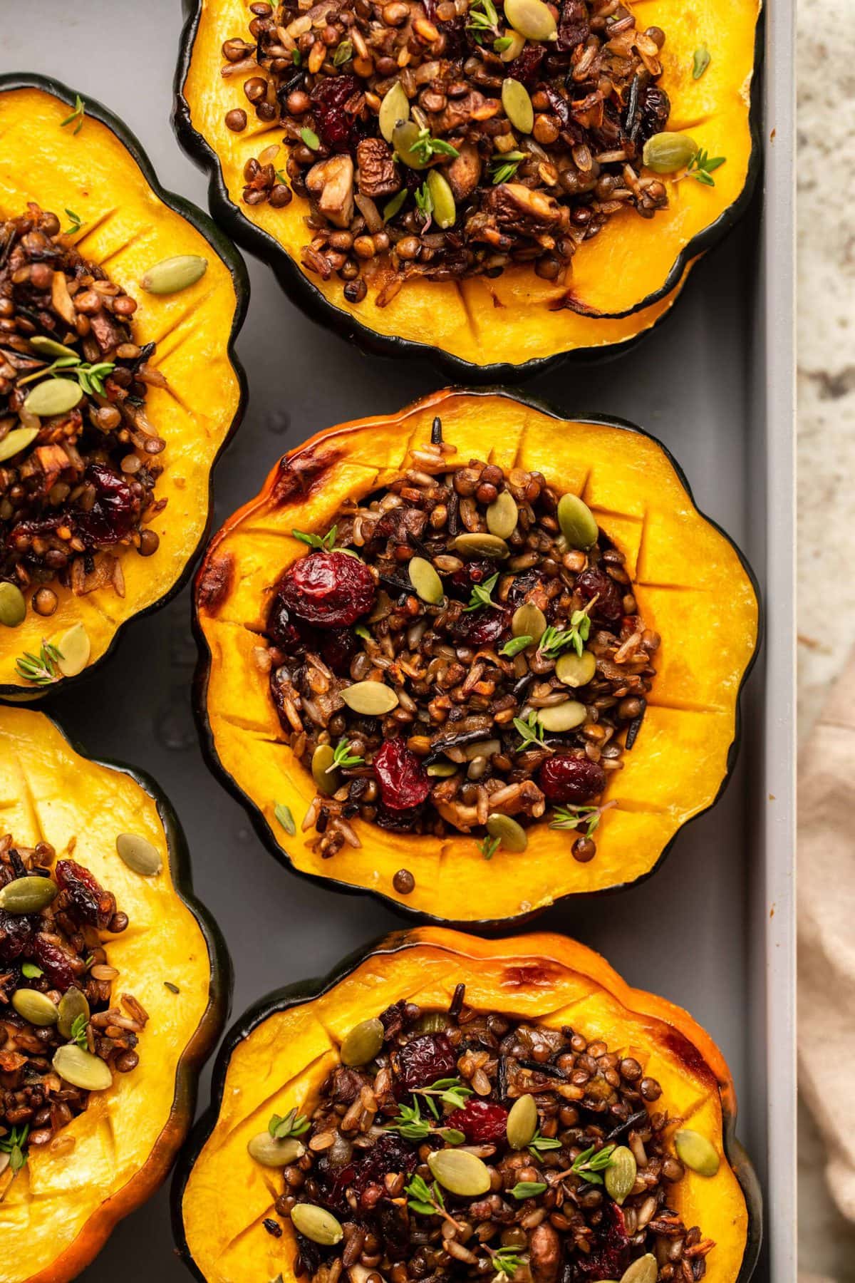 Cooked acorn squash stuffed with a crispy lentil and rice filling, then topped with pumpkin seeds