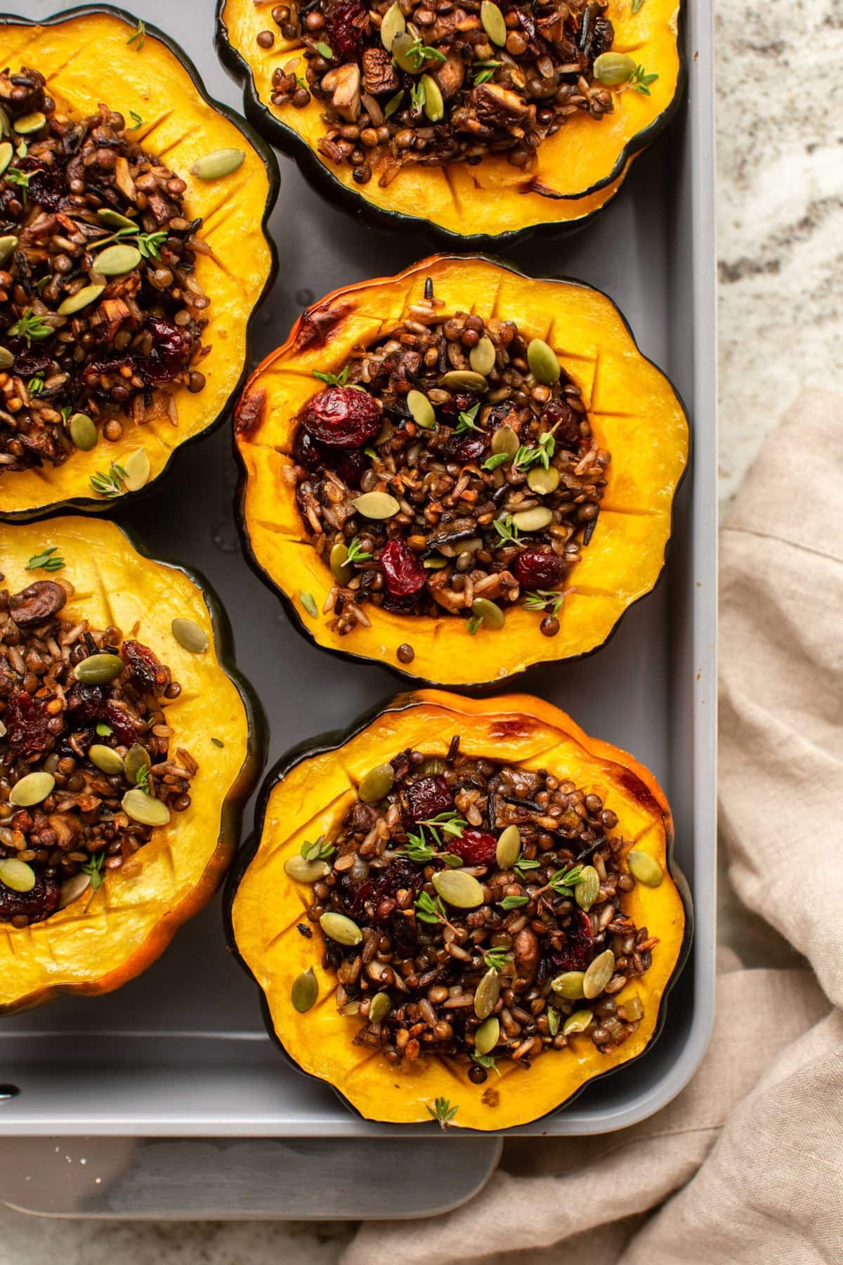 Cooked acorn squash stuffed with a crispy lentil and rice filling, then topped with pumpkin seeds