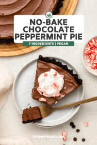 Slice of No-Bake Chocolate Peppermint Pie on white plate, topped with coconut cream and candy cane pieces