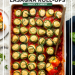 Baked Zucchini Roll Ups in baking dish with serving spoon holding two rolls topped with sauce and a sprinkle of fresh basil