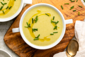 Bowl of vegan potato leek soup topped with olive oil and chives
