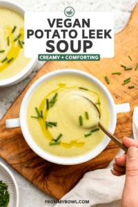 Bowl of potato leek soup with golden spoon taking a scoop of soup