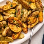 roasted potatoes on white dish sprinkled with parsley