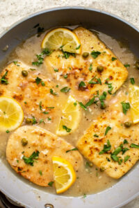 Vegan piccata in pan with lemon sauce topped with parsley