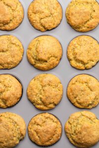 Overhead photo of golden baked muffin tops in baking tin