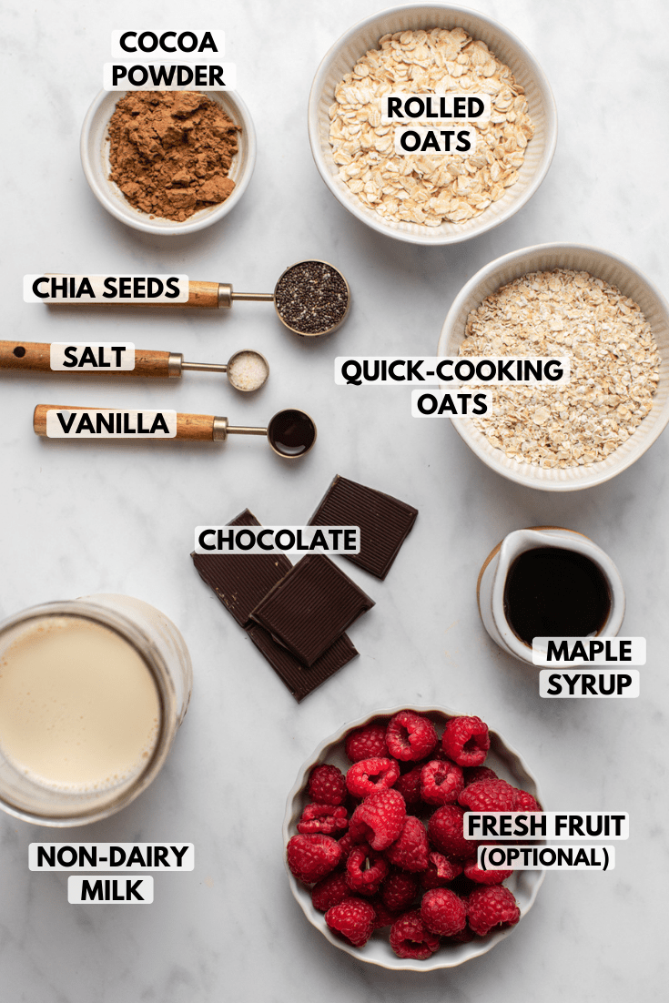 Ingredients for chocolate oatmeal in small bowls on marble background
