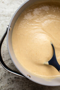 large pot of creamy blended parsnip soup with wooden spoon