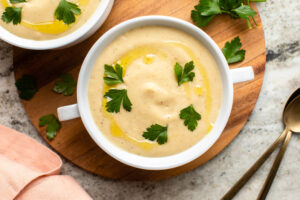 Parsnip Soup in white bowl with parsley and olive oil