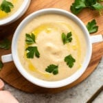 bowl of parsnip soup topped with parsley and olive oil