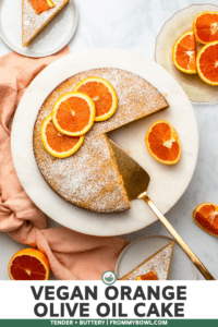 sliced orange cake topped with orange slices and powdered sugar on marble background