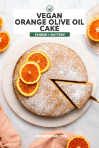 sliced orange cake topped with orange slices and powdered sugar on marble background