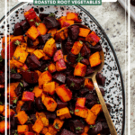 Roasted sweet potatoes and beets with spices on white serving tray with gold spoon