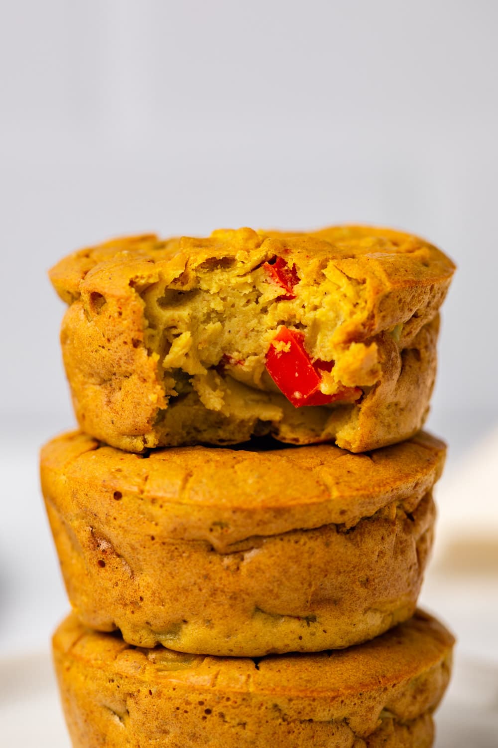 stack of vegan egg muffins with bite taken out of top one to show texture