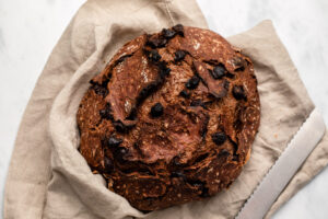 Double chocolate no-knead bread in linen napkin with bread knife