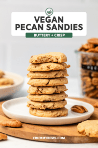 stack of vegan pecan sandies with jar of pecans in the back