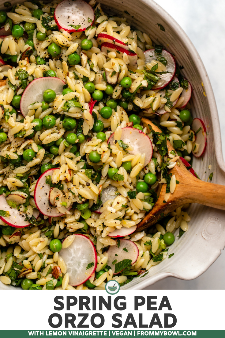 spring orzo salad in large mixing bowl with wooden spoon