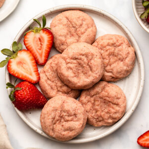 Strawberry sugar cookies and strawberries on white plate