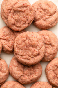 Close-up photo of strawberry sugar cookies arranged on white plate