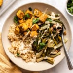 rice, roasted veggies, and tofu in bowl topped with tahini sauce
