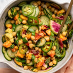 Spicy Peach and Chickpea Salad in large bowl with golden tongs