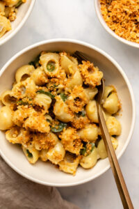 bowl of vegan jalapeño mac and cheese with garlic breadcrumbs on marble countertop