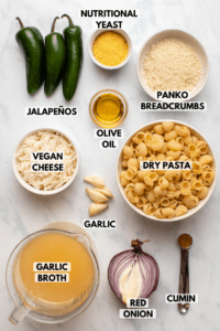 ingredients for vegan jalapeño mac and cheese in small white bowls on marble background