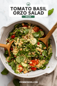 Tomato Basil Orzo Salad in large serving bowl with wooden tongs