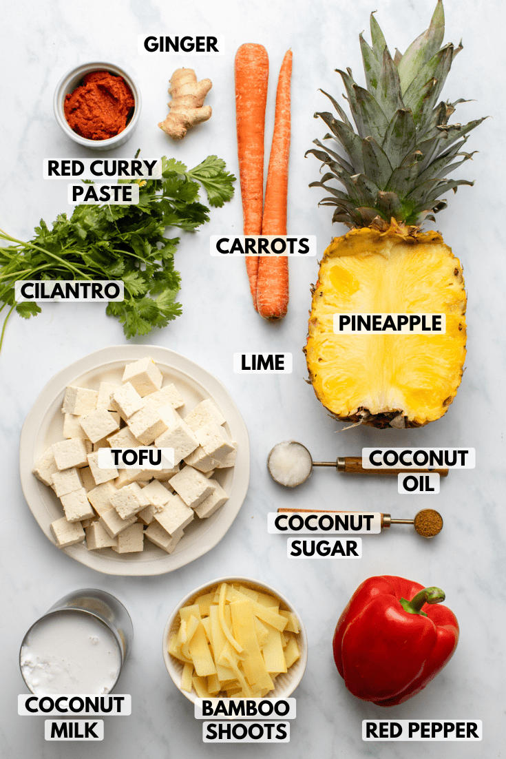 ingredients for pineapple curry in small bowls on marble background