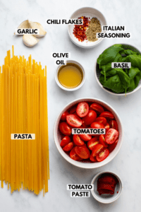 ingredients for spicy tomato basil pasta in small bowls on marble countertop