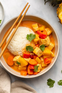 tofu pineapple curry in bowl with white rice and chopsticks