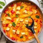 pineapple curry in large saute pan with wooden spoon