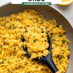 lemon pepper orzo in saute pan garnished with parsley and with lemon wedge on side