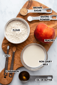 ingredients for peach cobbler in small white bowls on kitchen countertop