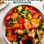 tomato cucumber salad in serving bowl topped with fresh basil
