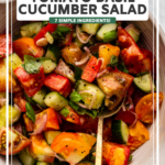 tomato cucumber salad in large serving bowl with golden spoon