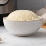 bowl of cooked white rice with instant pot in background