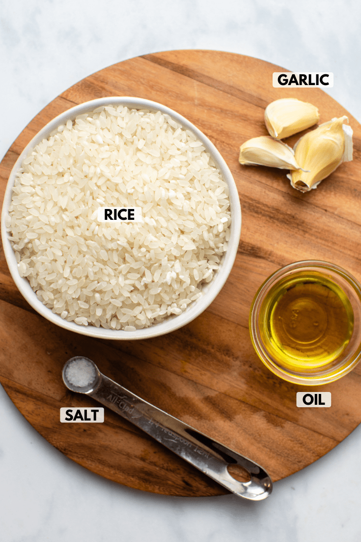 ingredients for garlic rice arranged on wooden cutting board