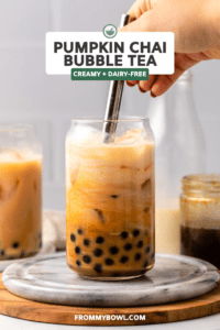 hand mixing glass of bubble tea with metal straw