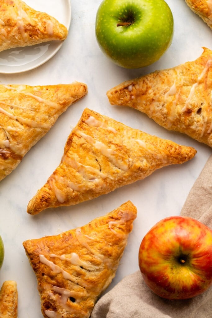 apple turnovers arranged on kitchen countertop with fresh apples