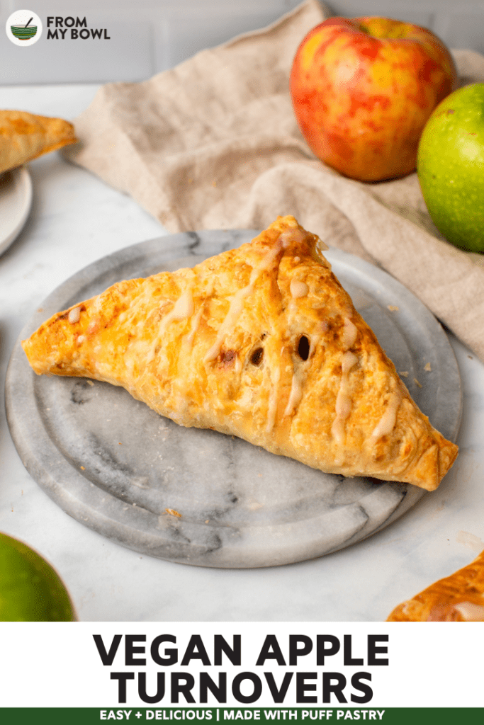 vegan apple turnover on marble cutting board with fresh apples in the background