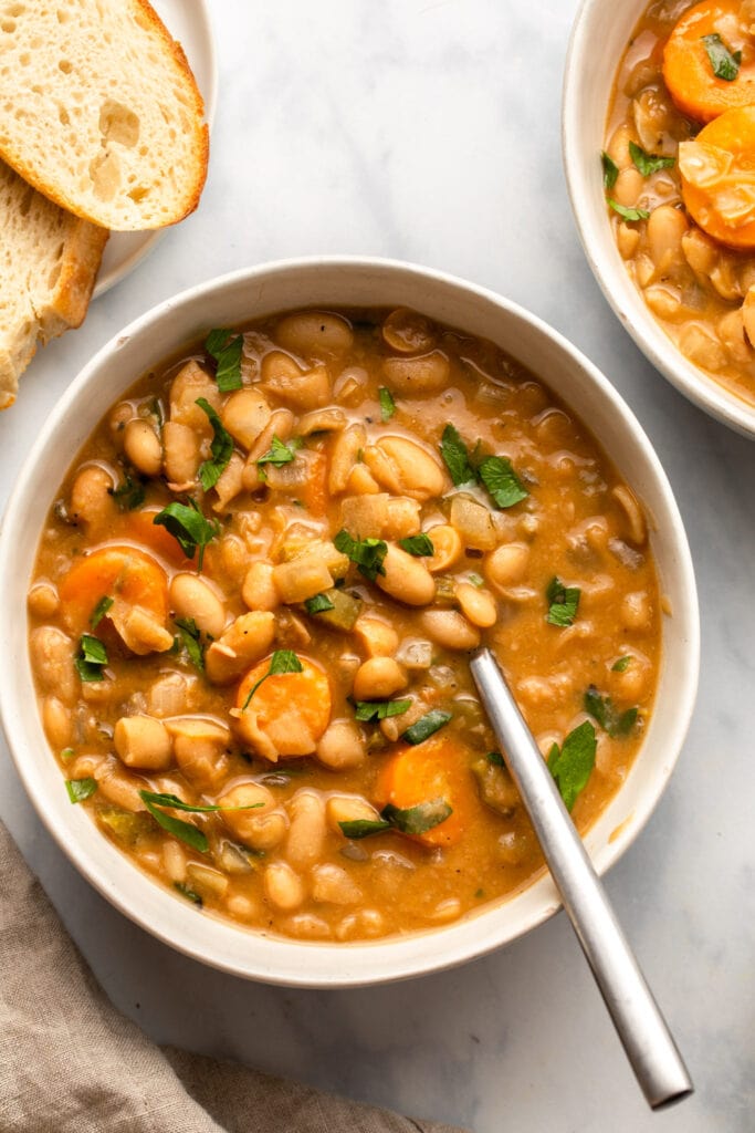 white bean stew in bowl with bread on the side