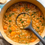white bean stew in dutch oven topped with fresh parsley